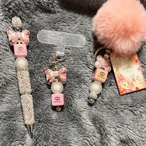 Pink and Silver 3 piece set. Includes Pompom keychain, pen and phone charm.